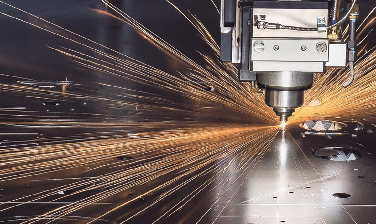Close-up of a precision laser cutting machine with bright orange sparks