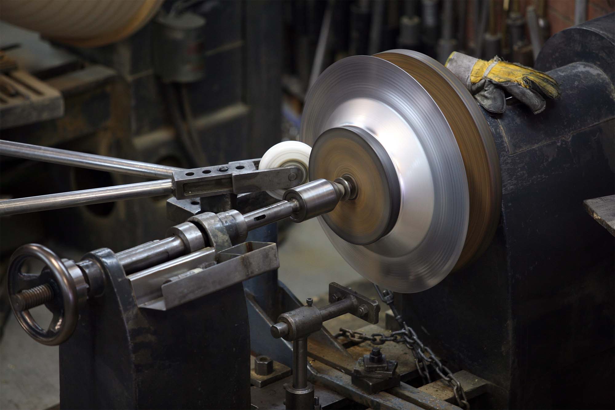 Metal spinning lathe in operation with a spinning metal disc